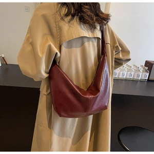 Detailed back view of a burgundy PU leather hobo shoulder bag styled with a khaki trench coat