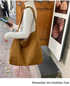 Detail of a large brown suede tote bag with matte texture for autumn fashion