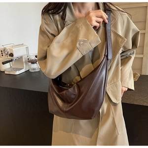 Detail of adjustable wide shoulder strap on dark brown vintage faux leather hobo bag