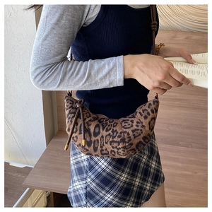 Borsa a mezzaluna con stampa leopardata indossata da modella in ambiente caldo