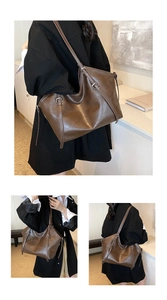 Detail view of large dark brown tote bag with adjustable straps and glossy PU leather finish