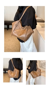 Close-up of retro brown tote bag with adjustable straps and textured synthetic leather