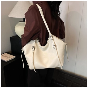 Detail of adjustable silver buckle on a minimalist cream PU leather tote bag strap