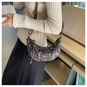 Dettaglio della borsa a mezzaluna leopardata con tracolla marrone e zip in metallo