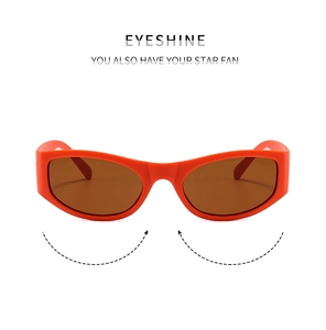 Detail view of Y2K futuristic orange oval sunglasses with dark brown lenses on white backdrop