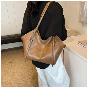 Detail view of the vintage brown tote bag with adjustable multi-hole buckle strap