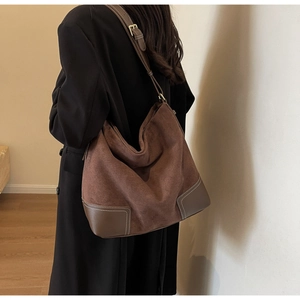 Detailed side view of large brown suede tote bag featuring adjustable leather shoulder strap