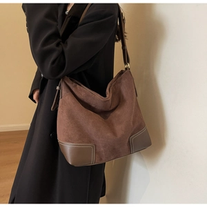 Detail of vintage brown suede tote bag featuring reinforced leather corners and contrast stitching