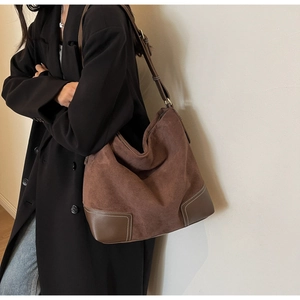 Detail of suede tote bag with leather corner patches and contrast white stitching