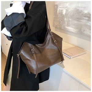 Detailed view of deep brown oversized tote bag with adjustable buckle strap detail