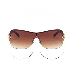 Detail of Y2K shield sunglasses featuring brown gradient lenses and golden temple accents