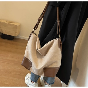 Detail of vintage suede tote with brown leather corners and white contrast stitching