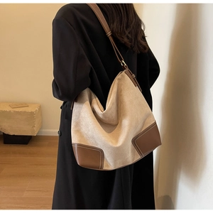 Detail of suede hobo tote with brown leather corners and contrast stitching