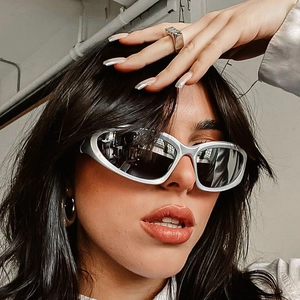 Futuristic silver Y2K wraparound sunglasses with dark reflective lenses on a model