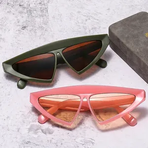 Lunettes de soleil triangulaires chic en vert olive et rose sur fond de marbre