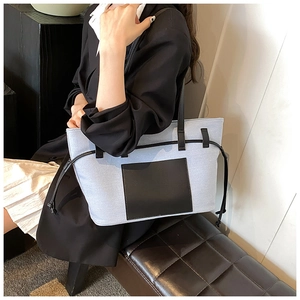 Schicke hellblaue Segeltuchtasche mit schwarzer Ledertasche getragen am Model