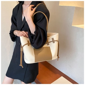 Detail der Canvas-Einkaufstasche mit braunem Lederbesatz und Kordelzug an der Schulter