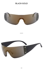 Detail of black and gold Y2K shield sunglasses featuring silver star studs on the frame
