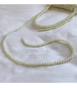 Détail d'un sac à main en perles tissé à la main avec une longue bandoulière en perles