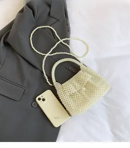 Vue détaillée du sac à main en perles fait main montrant la taille par rapport au téléphone