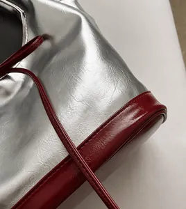 Close-up of silver and deep red PU leather texture with natural folds on a tote bag