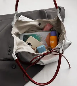 Spacious interior of silver PU tote bag showing capacity for tablets and cosmetics