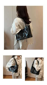 Detail of a black high-gloss PU shoulder bag with side bow strap and sleek texture