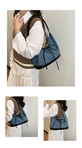 Detail of blue denim hobo bag featuring black leather trim and bow knot detail