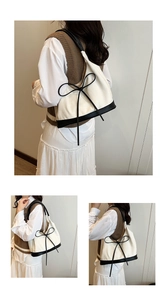 Detail of canvas tote bag with black bow decoration and leather trim on a model
