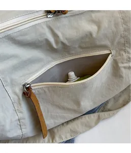 Detail of nylon dumpling bag with metal zipper and herringbone pattern inner lining