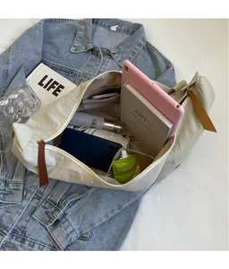 Detailed internal compartments of a large beige nylon crossbody bag showing ample storage