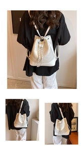 Detail of white quilted drawstring bucket bag featuring chain straps and PU leather texture