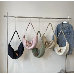 Detail shot of multi-color nylon crescent dumpling bags hanging on a display rack