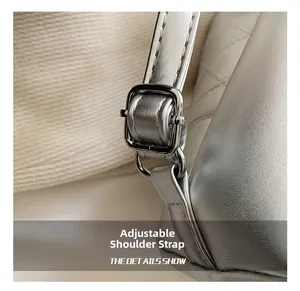 Detail of adjustable metal buckle and stitching on silver leather bucket bag