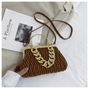 Detail van bruine geplooide schelptas met gouden ketting en retro sluiting