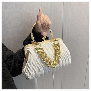 Detail van witte geplooide handtas met gouden ketting en vintage sluiting