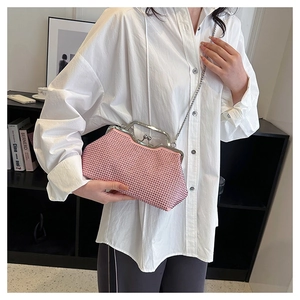 Detail of pink rhinestone evening clutch featuring a metal frame and chain strap