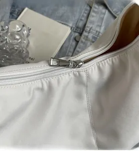 Detailopname van een zilveren rits op een witte nylon tote bag voor dagelijks gebruik