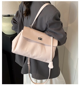 Close-up of a light pink lychee texture leather shoulder bag with silver metal swivel lock