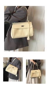 Detail of cream lychee texture leather shoulder bag with silver turn-lock and slim strap