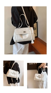 Close-up of white lychee pattern leather underarm bag with elegant metal buckle detail