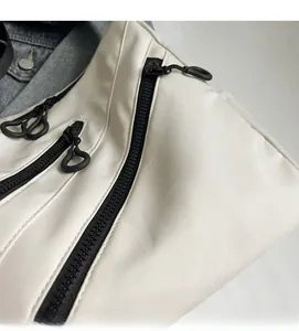 Close-up of white nylon tote fabric with black industrial zipper and circular puller