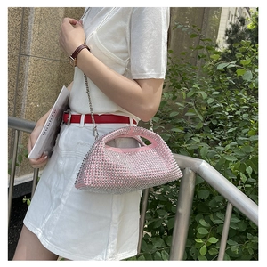 Detail of pink rhinestone handbag featuring a silver chain strap and sparkling crystals