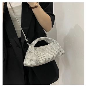 Detail of silver rhinestone evening bag with elegant chain strap on a black blazer