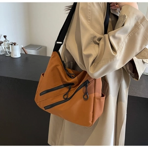 Detailed shot of yellow nylon crossbody tote bag with multi-layer zipper pockets