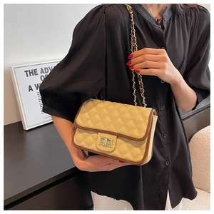 Dettaglio borsa trapuntata beige con bordo marrone scuro e chiusura dorata girevole