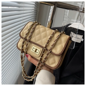 Dettaglio borsa a tracolla in pelle trapuntata beige con chiusura dorata e catena