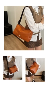 Close-up of caramel orange vintage pillow bag with wide strap and silver zipper detail