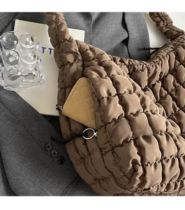 Close-up of brown quilted tote bag showing hidden zipper pocket with a card holder inside
