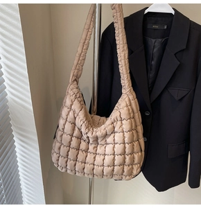 Close-up of beige quilted puffy cloud bag with soft textured fabric and glossy finish